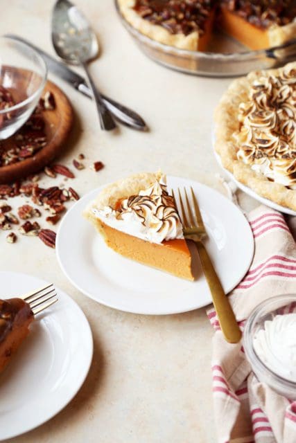Slice of sweet potato pie with meringue on a small white plate.