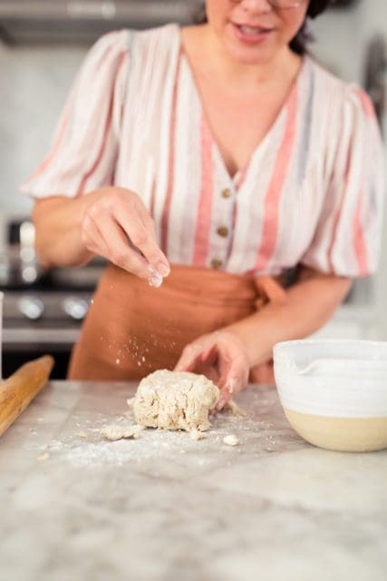 Dusting flour on top of gluten-free pie crust dough.