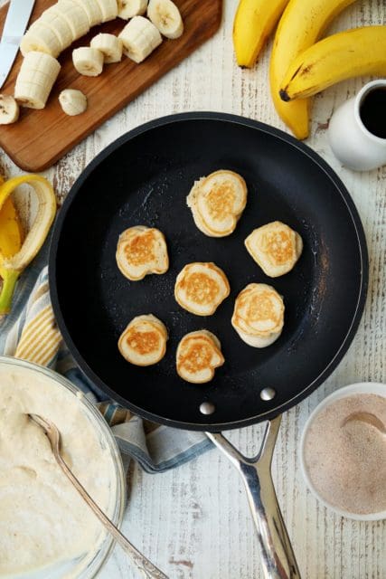 Banana pancakes cooking in a skillet