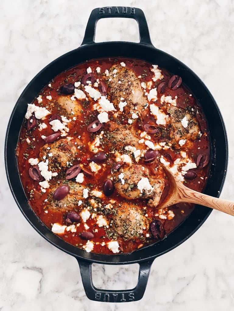 An easy chicken dinner recipe of tomatoes and feta in a cast iron skillet.