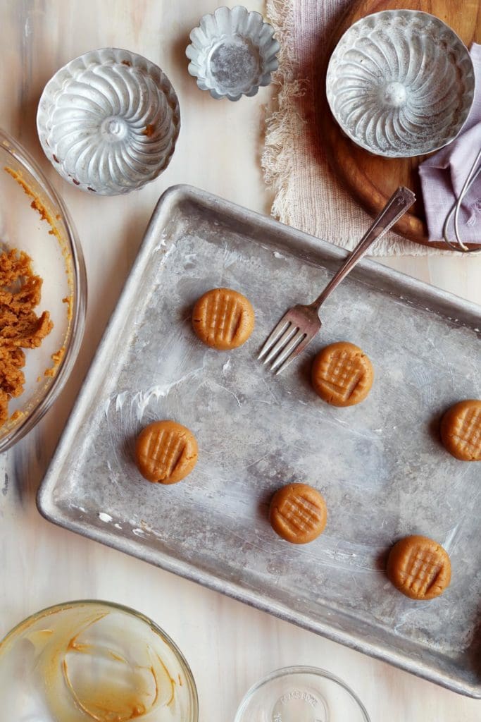Peanut butter cookie dough balls on a baking sheet.