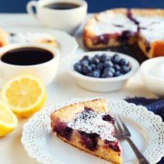 A slice of lemon blueberry cake on a small plate with fork,