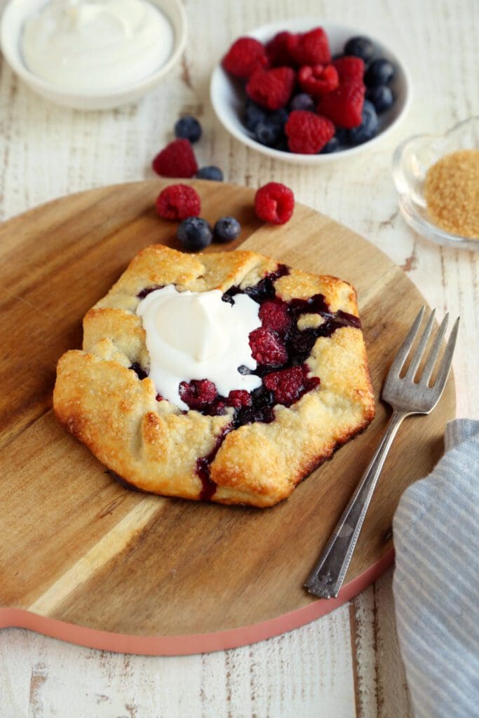 Berry crostata topped with whipped cream with coffee.