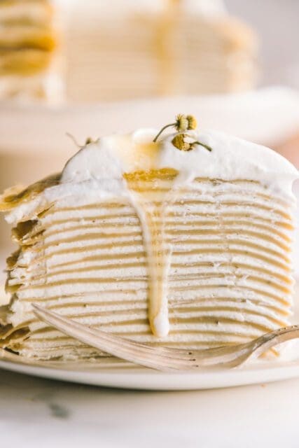 photo of the layers of crepes and cream with honey dripping down the side