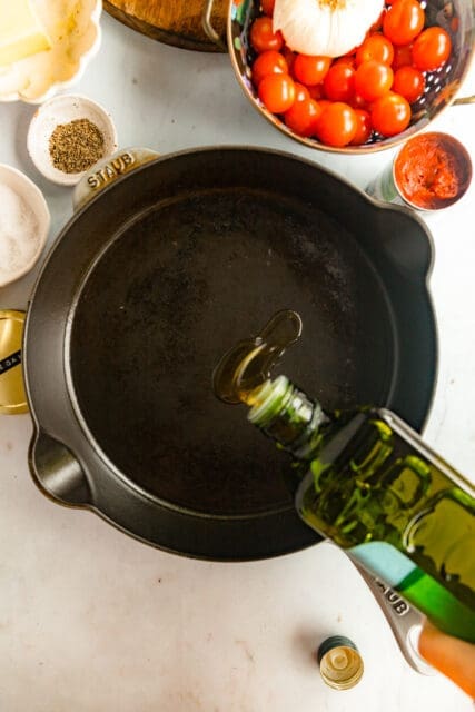 heating olive oil in a cast iron pan for baked polenta
