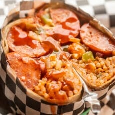 jambalaya breakfast burritos cut in half and topped with hot sauce